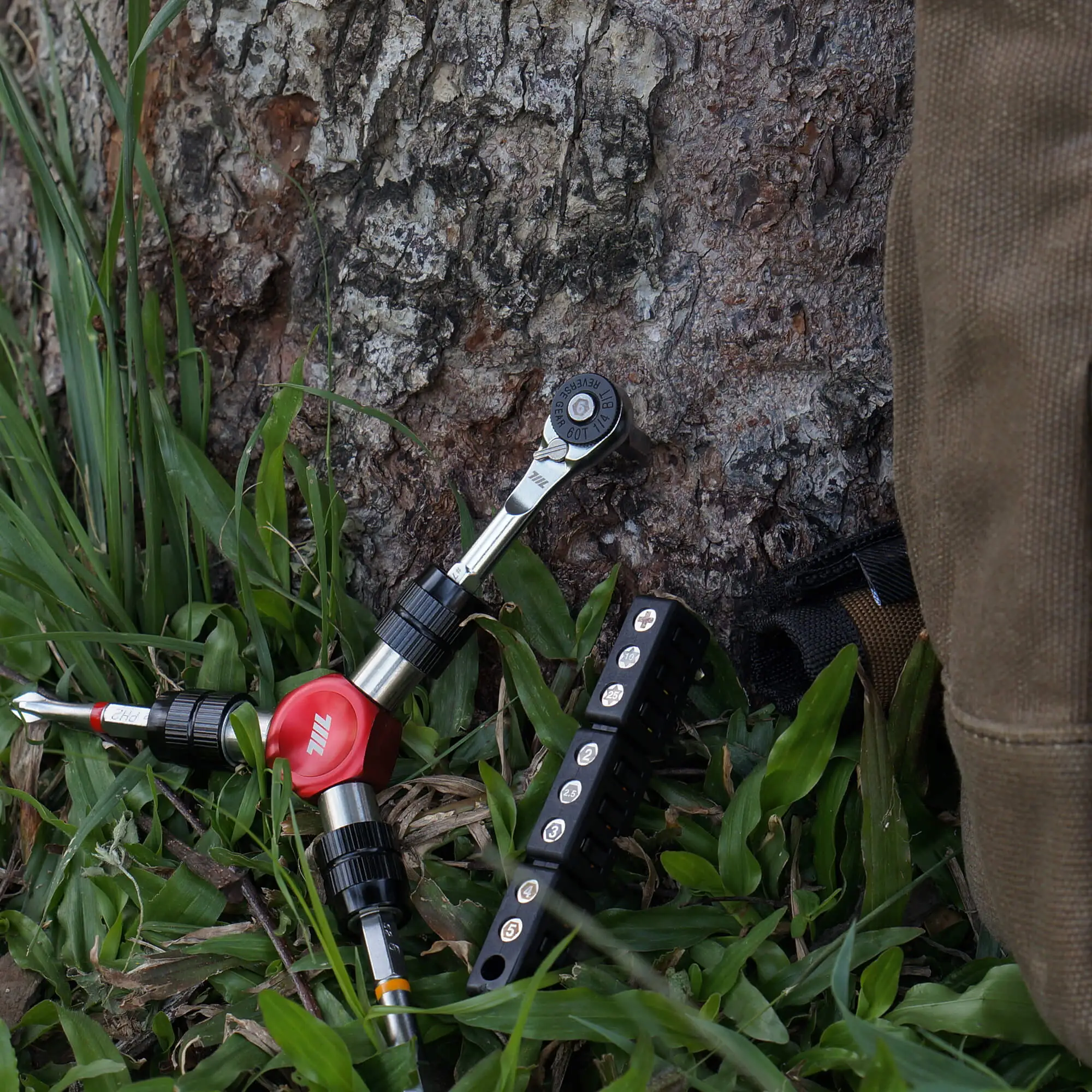 Outdoor use of the 711L bits from the 9pcs color‑coded 1/4” set on a tree trunk - showcasing the complete bit set’s versatility for professional repair tasks