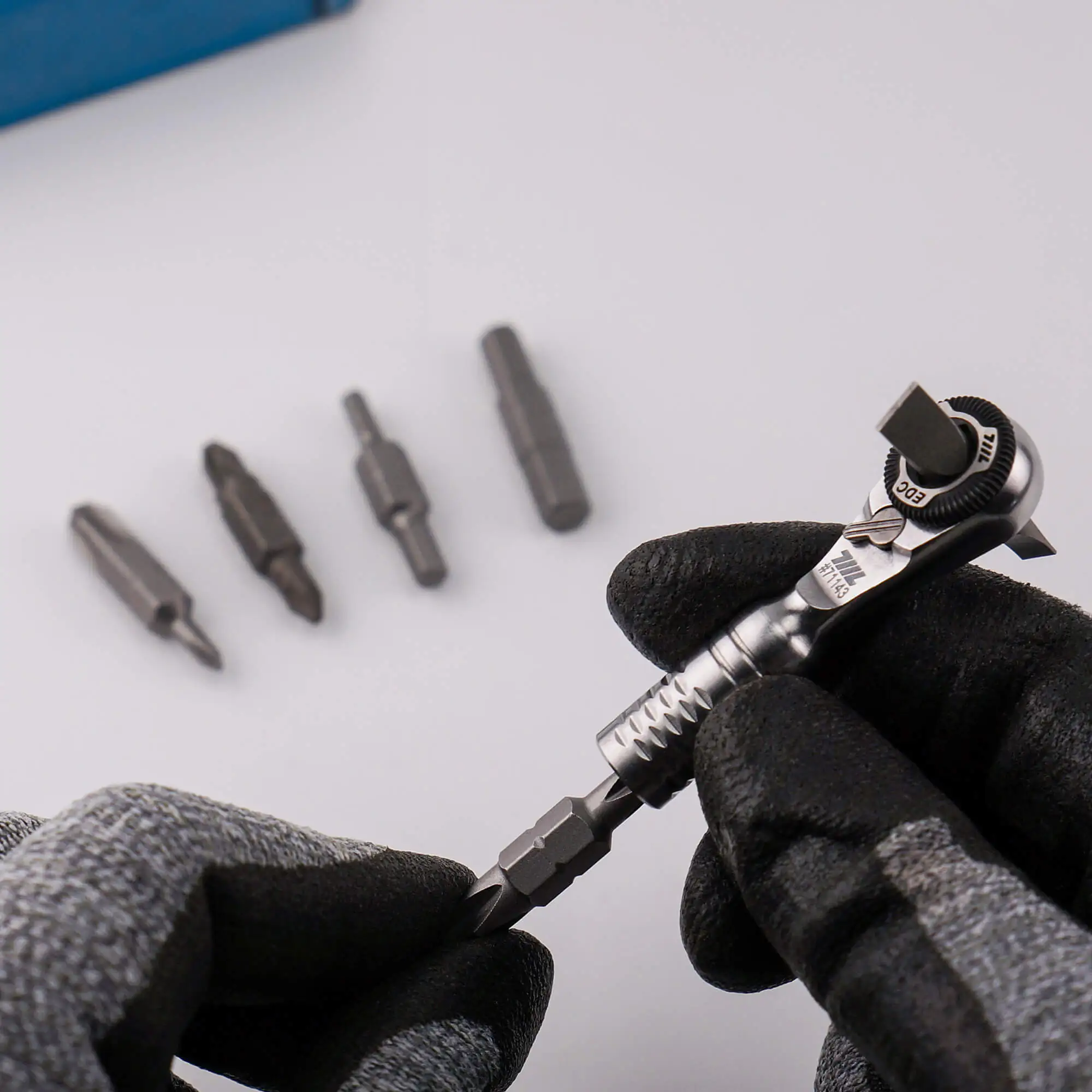 Gloved hand inserting a double-ended bit into the 711L Mini Ratchet Wrench TG